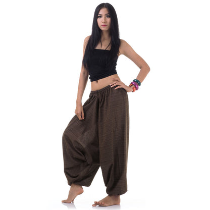 Side view of model in brown women pinstripe drop crotch thai harem pants with black top