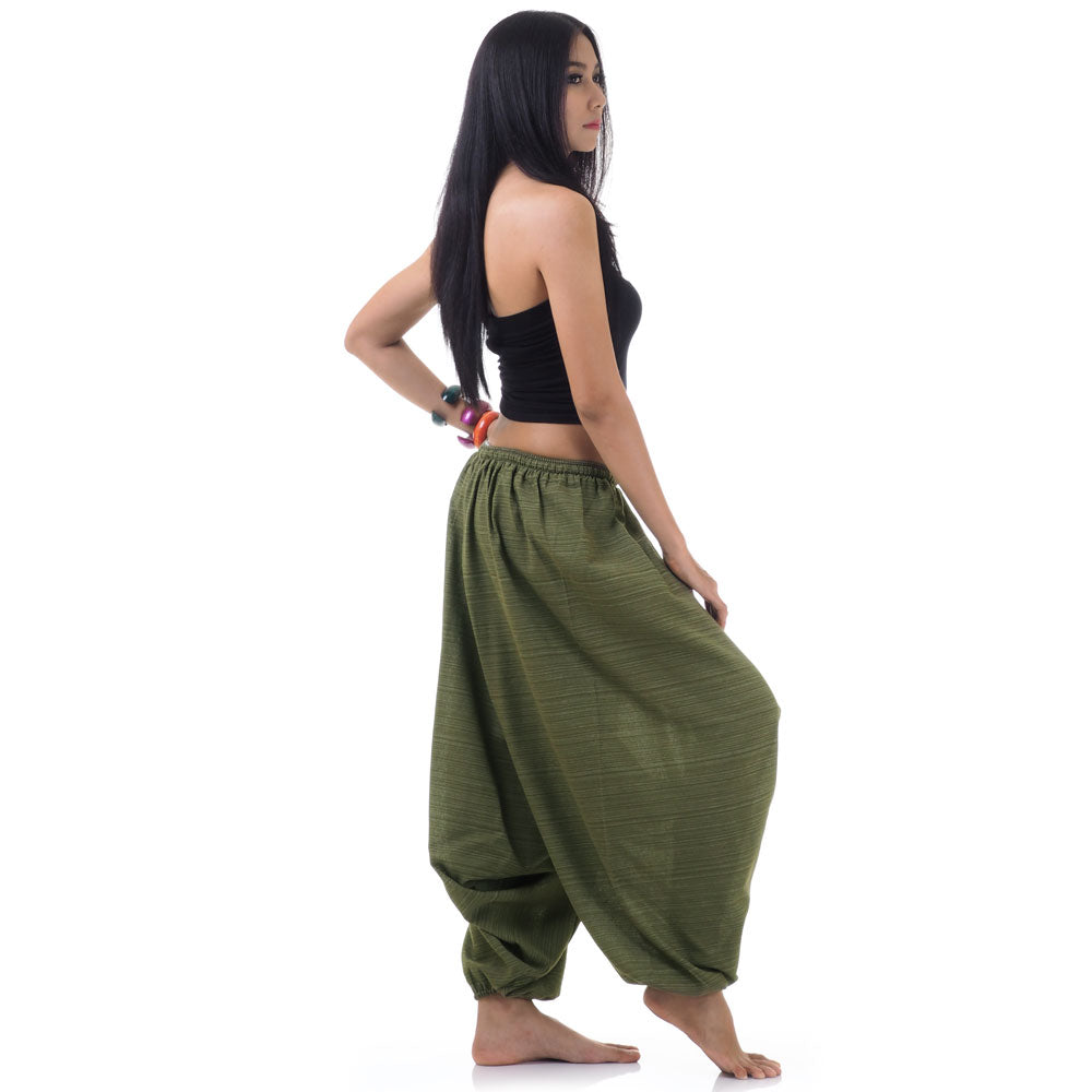 Side view of model in green women pinstripe drop crotch thai harem pants with black top