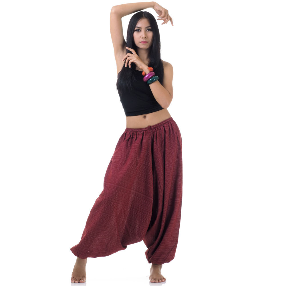 Model wearing maroon women pinstripe drop crotch thai harem pants with black top, front view