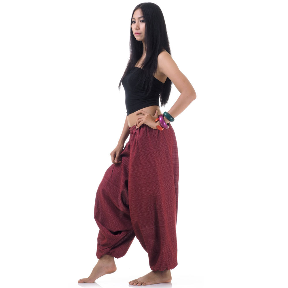 Side view of model in maroon women pinstripe drop crotch thai harem pants with black top