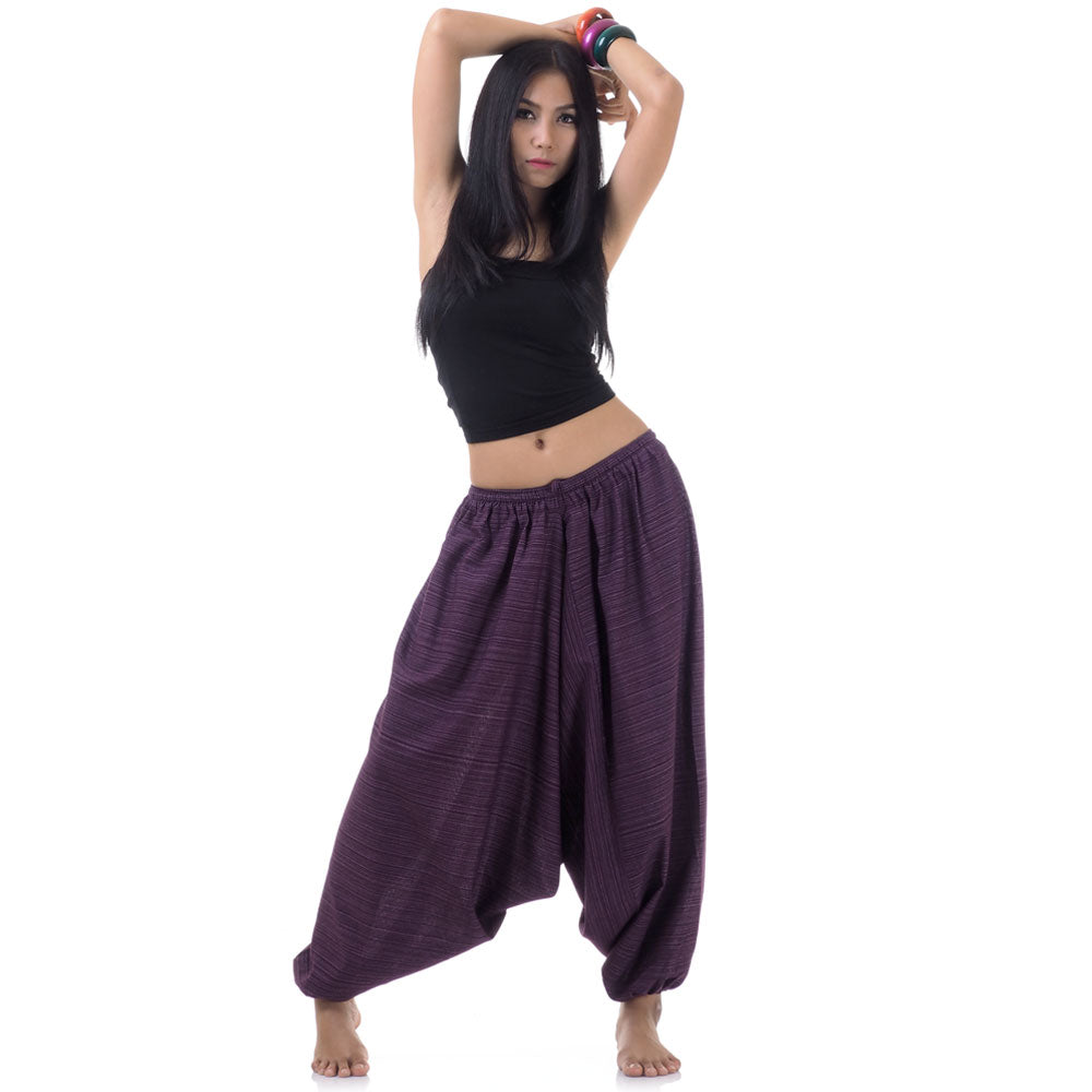 Model wearing purple women pinstripe drop crotch thai harem pants with black top, front view
