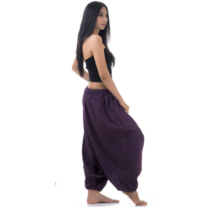 Side view of model in purple women pinstripe drop crotch thai harem pants with black top