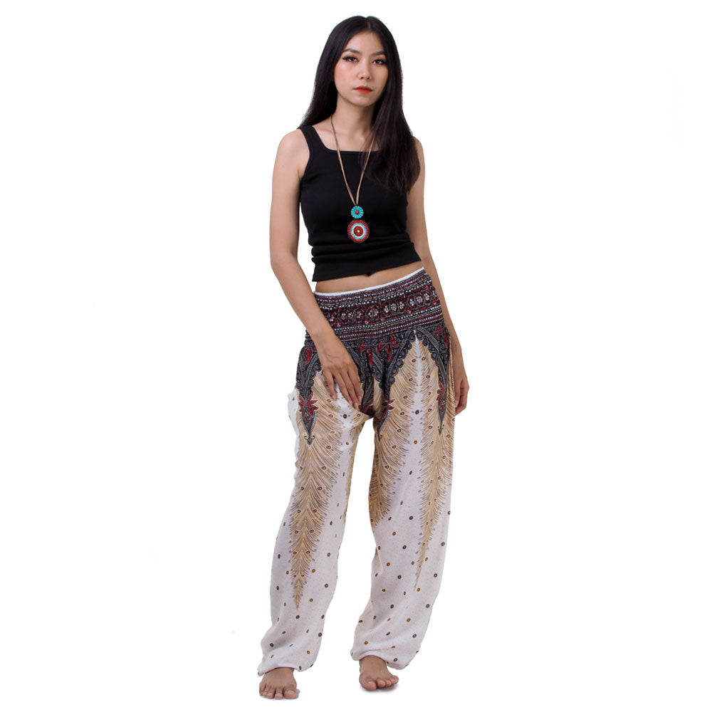 Model wearing white Thai harem yoga pants with peacock print and black top, front view