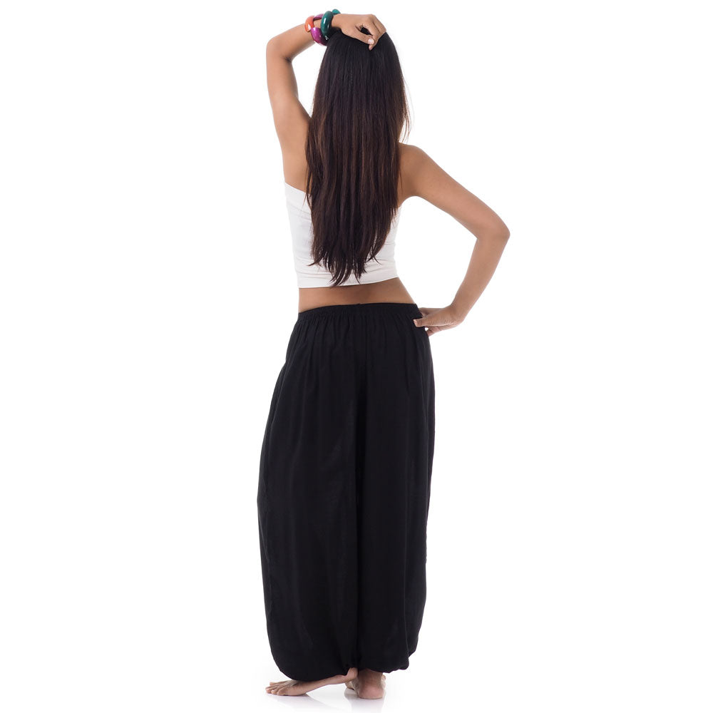 Back view of a female model wearing midnight black Thai pants, comfortable free-moving fit S-M.