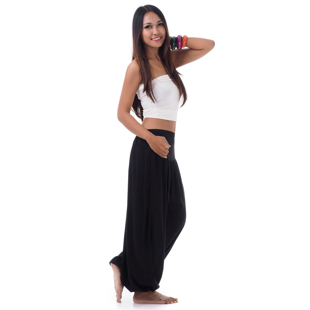 Side view of a female model in midnight black boho pants showcasing the practical side pockets.