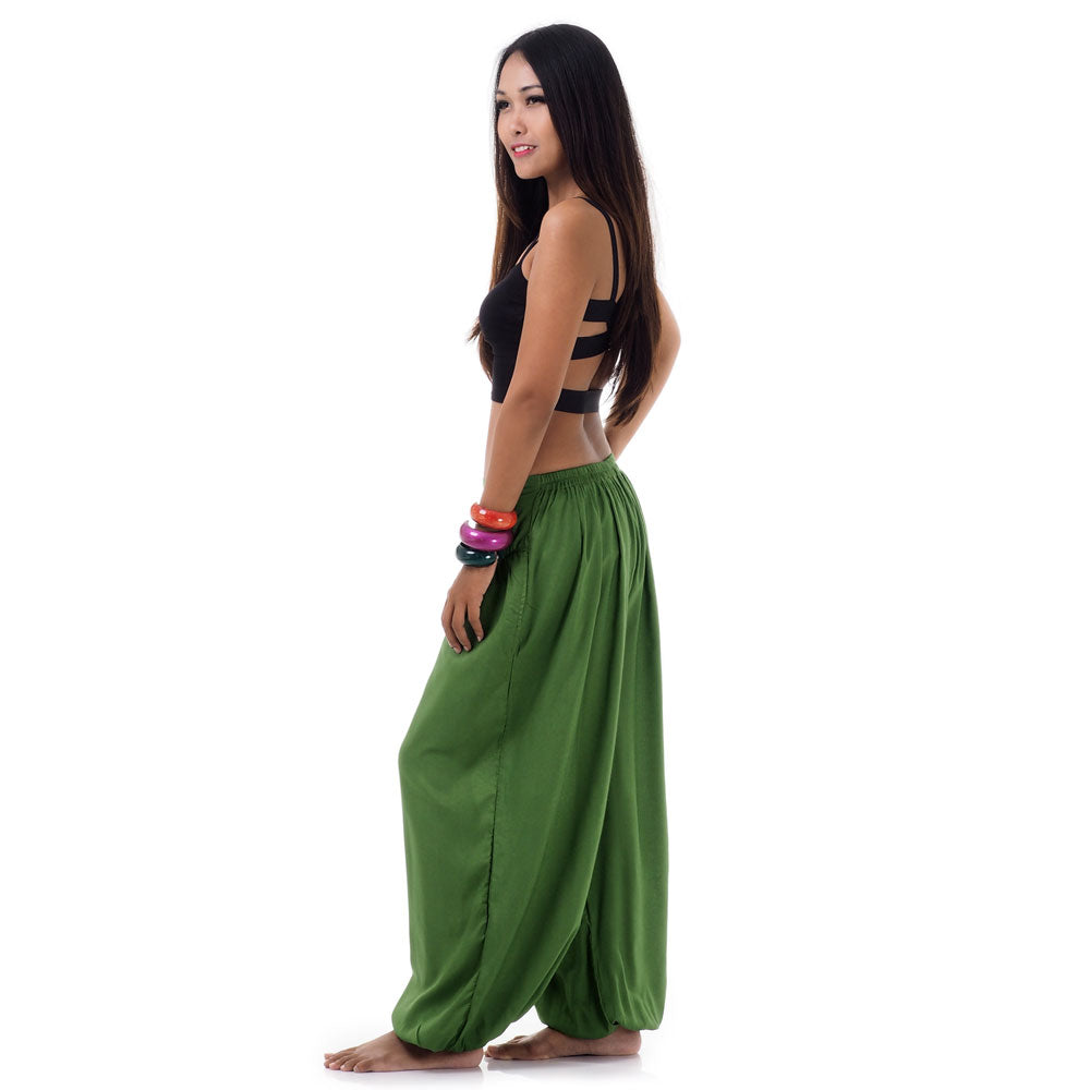 Side view of a female model in emerald oasis boho pants highlighting the two side pockets.