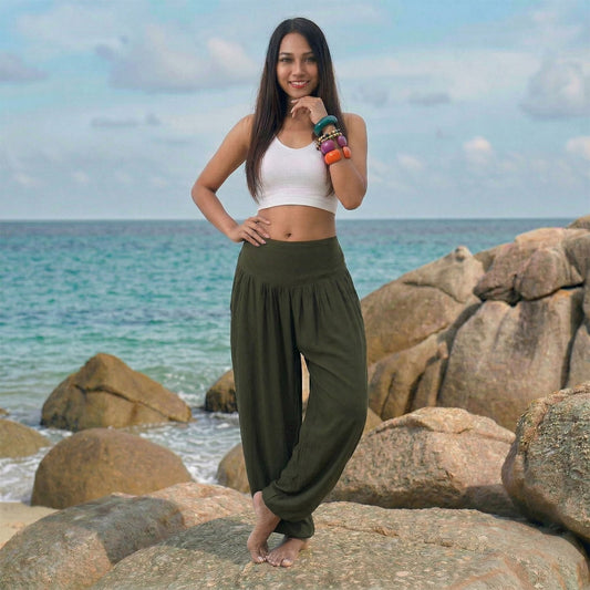 Female model in olive grove Thai harem pants walking on a Thai beach, highlighting the earthy handmade color.