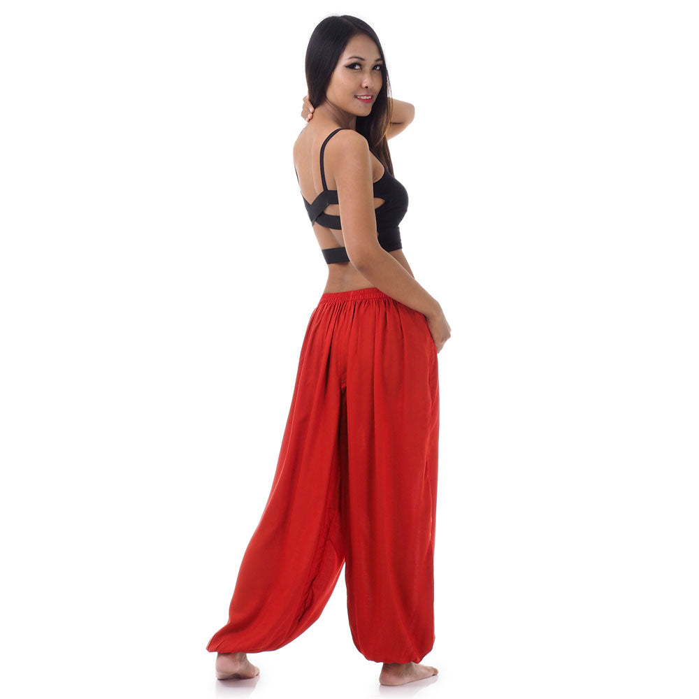 Back view of a female model wearing sunset red Thai pants, flexible fit for ultimate comfort.
