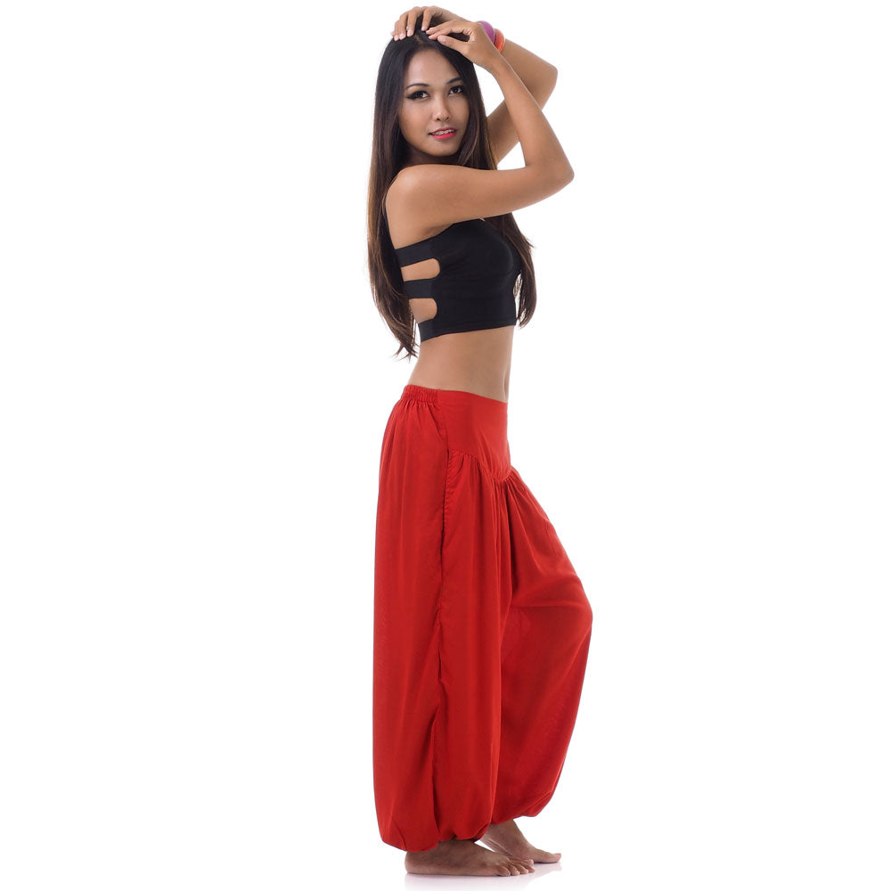 Side view of a female model in sunset red boho pants highlighting the elasticated ankle cuffs.