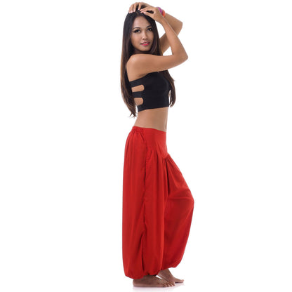 Side view of a female model in sunset red boho pants highlighting the elasticated ankle cuffs.