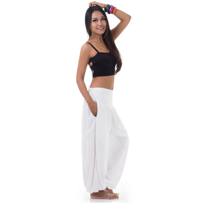 Side view of a female model in sunny white boho pants with two convenient side pockets.
