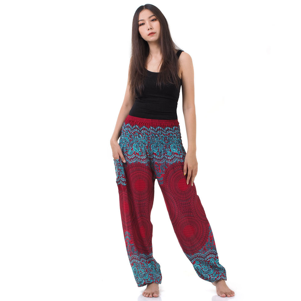 Model wearing red Thai harem yoga pants with mandala print and black top, front view