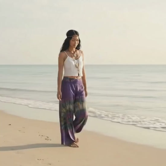 Video: Female model strolling on a sunny sandy Thai beach wearing the fluid Royal Purple Hippie Tie Dye Palazzo Pants.