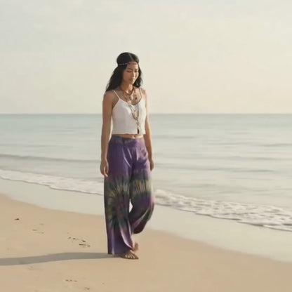 Video: Female model strolling on a sunny sandy Thai beach wearing the fluid Royal Purple Hippie Tie Dye Palazzo Pants.