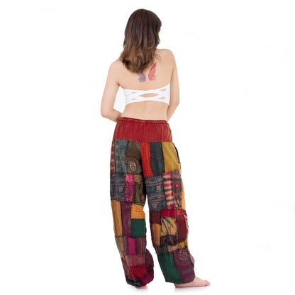 Back view of a  multicolored patchwork Thai harem yoga pants worn with white top