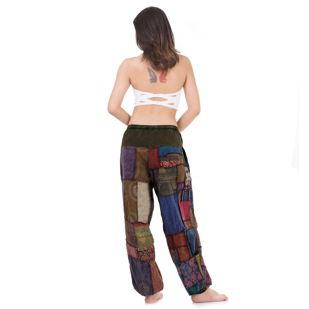 Model wearing multicolored patchwork Thai harem yoga pants and white top, back view